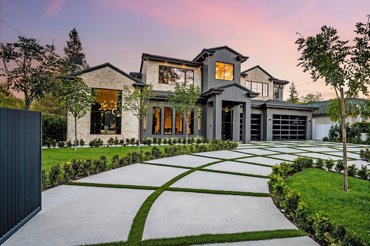 Modern home exterior with a well-manicured lawn and geometric driveway